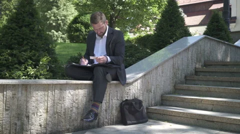 Businessman is writing down data from card to documents. Video stock 52773515