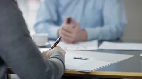 Businessman writing down something on his paper in a meeting Stock Footage 85266483