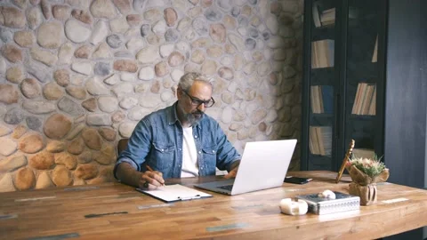 Businessman writing notes on the paper from the computer in his office. Stock Footage 135720818