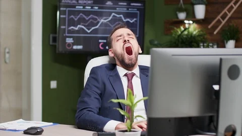 Businessman yawning while typing on the computer Stockbeeldmateriaal 109609910