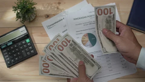 Businessman's hands counting US dollar bills on a wooden desk covered Stock-Footage 346771145