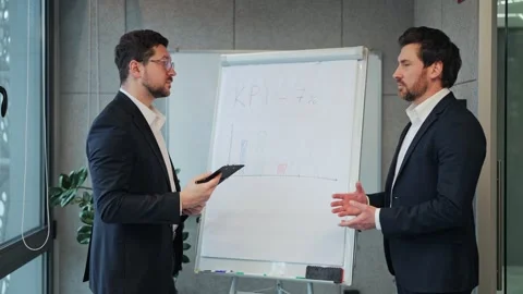 Businessmen Analyzing KPI Data in Office Meeting Stock Footage 330155692