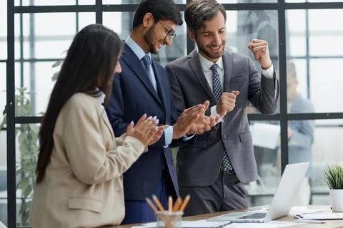 Businessmen clapping their hands while standing in the office Stock Photos