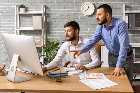 Businessmen with computer and documents negotiating in office Stock Photos