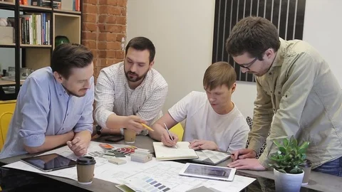 Businessmen discuss drawing sitting at the table in office. Stock Footage 78566090