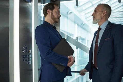 Businessmen Discussing Strategy in Elevator 스톡 일러스트