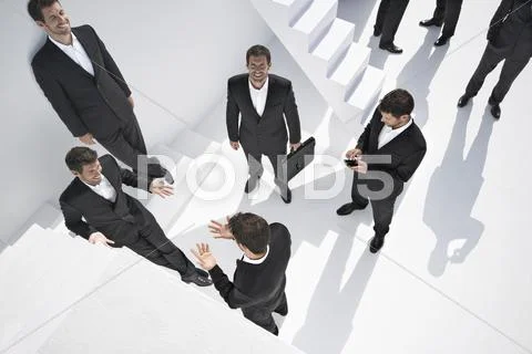 Businessmen doing various activities near stairs Stock Photos