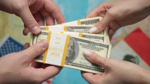 Businessmen exchange stack of dollars against US and Mexican flags with world Stock Footage 331263389