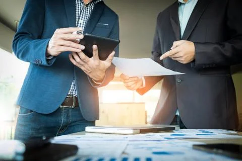 Businessmen hands pointing at document in touchpad during explanation of new Stock Photos