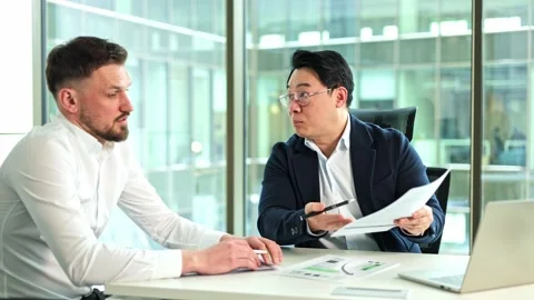 Businessmen Having a Discussion Over Documents in a Modern Office Stock-Footage 304105148