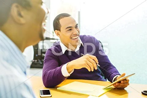 Businessmen Laughing In Office Meeting