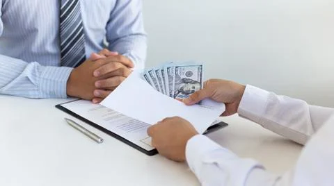 Businessmen make dollar payments while signing an investment agreement to be Stock Photos