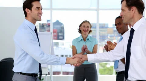 Businessmen shake hands while other business people applauding Stock-Footage 23387539