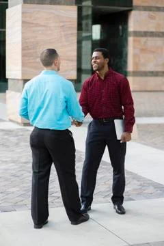 Businessmen shaking hands outdoors Foto stock