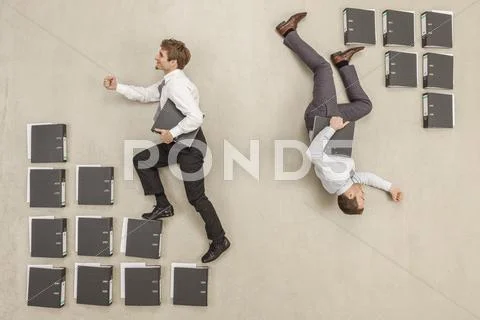 Businessmen stepping on files in opposite direction Stock Photos