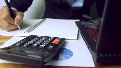 Businessmen use his calculator to get the results of the company to report to Stock Footage