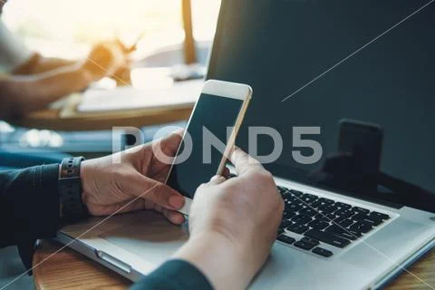 Businessmen use smartphones and laptop to connect and find infor Stock Photos