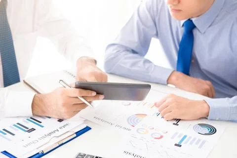 Businessmen using tablet computer discussing financial data Stock Photos