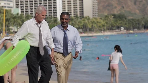 Businessmen walking on a beach with an inflatable. Stock-Footage 88369323