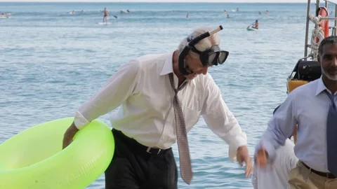Businessmen walking on a beach with an inflatable. Stock Footage 88369378