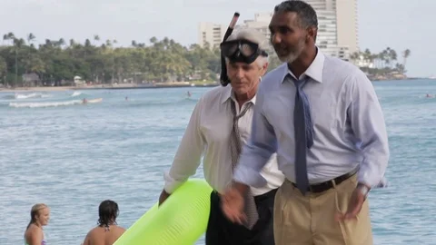 Businessmen walking on a beach with an inflatable. 스톡 동영상 88369385