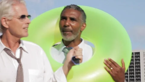 Businessmen walking on a beach with an inflatable. Stock Footage 88369397