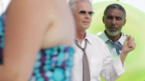 Businessmen walking on a beach with an inflatable. 스톡 동영상 88369419