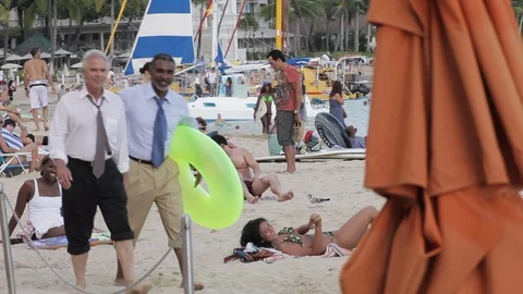 Businessmen walking on a beach with an inflatable. Stock Footage 88369430