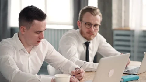 Businessmen work together at two laptops, talk discuss collaborate together. men Stock-Footage 133218408