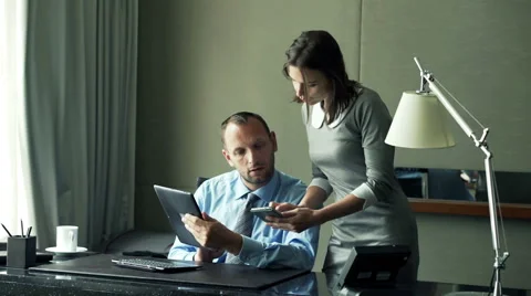 Businesspeople comparing data on tablet computer and smartphone in office Stock Footage 54694427