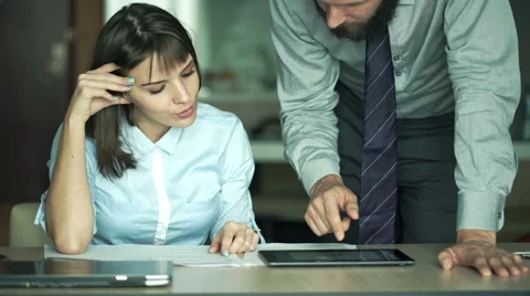 Businesspeople comparing data on tablet computer and documents in office Stock Footage 57228740