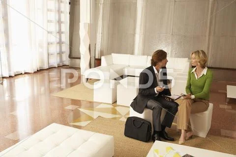 Businesspeople Discussing In Office Lobby Stock-Fotos