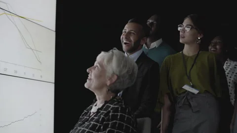 Businesspeople laughing during a presentation on a multiscreen office wall Stock Footage 138137282