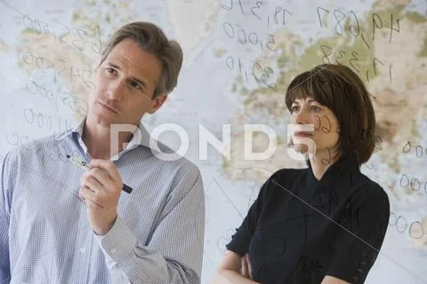 Businesspeople looking at dry erase board Stock Photos