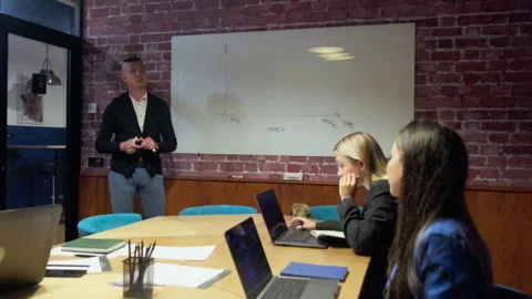 Businesspeople sit at large table with laptops in boardroom Stock Footage 276229905