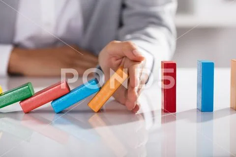 Businessperson Hand Stopping Colorful Blocks From Falling Stock Photos
