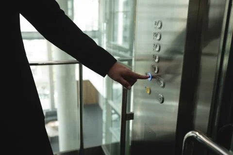 Businessperson pressing a button in the elevator Foto stock