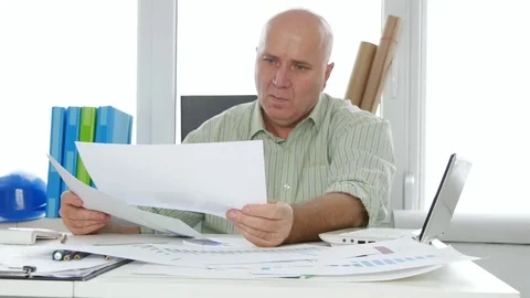 Businessperson Study Documents Plans and Papers with Charts and Calculations Stock Footage 82963940