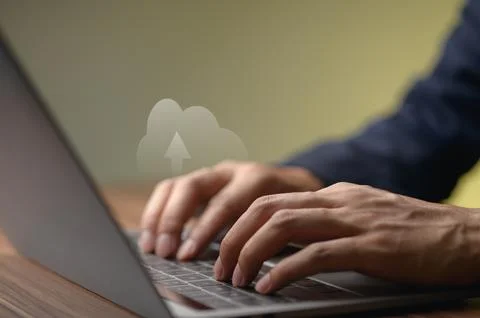 Businessperson Typing on Laptop with Cloud Computing Concept in Background Fotos Stock