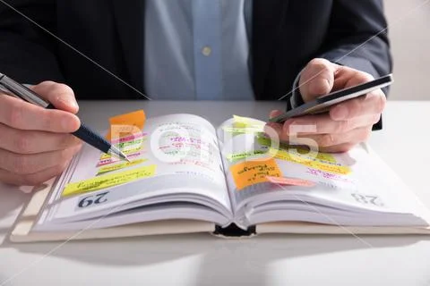 Businessperson Writing Schedule In Diary Stock Photos