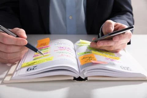 Businessperson Writing Schedule In Diary Stock Photos