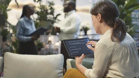 Businesswoman analyzes code using AI model on tablet in rooftop lounge Stock Photos