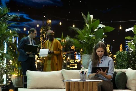Businesswoman analyzes project notes using tablet in rooftop lounge Stock Photos
