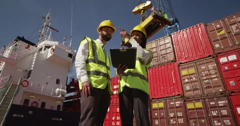 Businesswoman and dock worker shake hands at a busy shipyard. Shot on RED Epic. Stock Footage