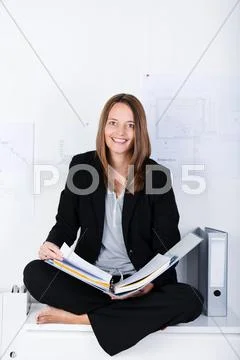 Businesswoman with binder sitting on counter Stock Photos