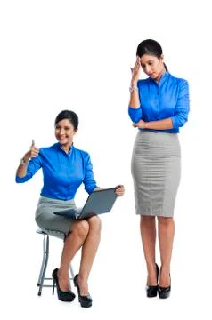 Businesswoman celebrating her success with her clone standing beside her Stock Photos
