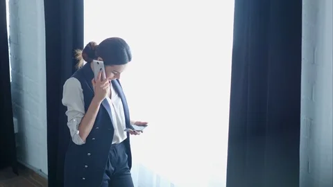 Businesswoman on cellphone talking, while using the other smartphone Vídeos de archivo 77414542