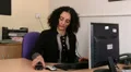 Businesswoman chatting on mobile sitting at desk HD Footage