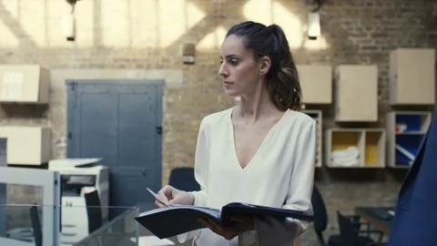 Businesswoman checking a file while walking around office Stock Footage 107891330