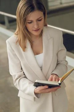 Businesswoman checking notes in planner while walking on street Stock Photos